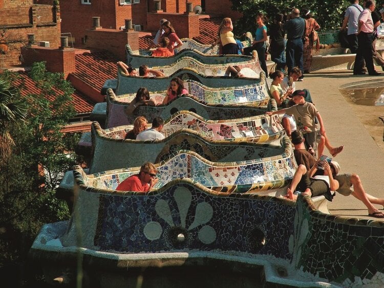 <span>Sun yourself on the world’s longest park bench at Park Guell - it’s covered in colorful mosaics made from broken plates, cups, and dishes</span>